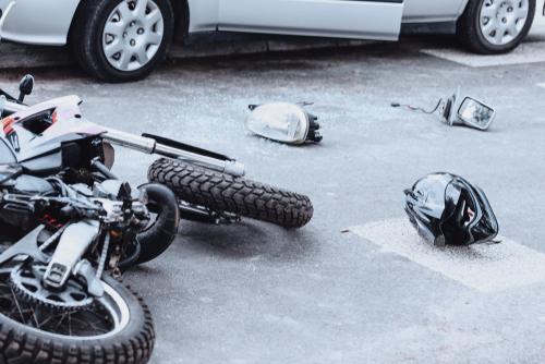 Car,Mirror,,Headlight,,Helmet,And,Motorcycle,Lying,On,The,Road